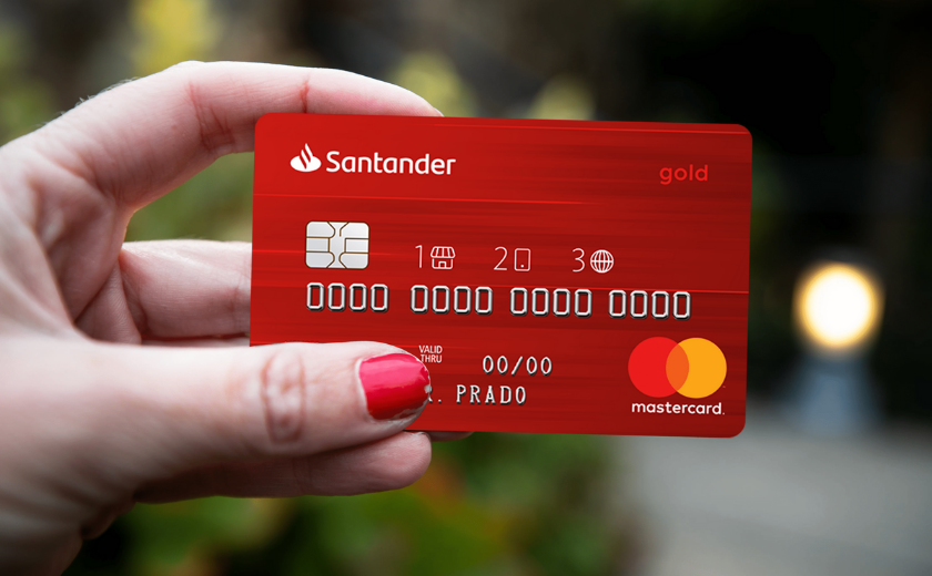 uma mão segurando o cartão santander 1|2|3
