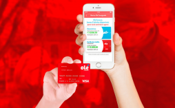Uma mão segurando o cartão Olé Consignado, enquanto outra mão segura um celular com o aplicativo do Banco Olé