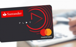 Cartão santander play e uma pessoa estudando atrás